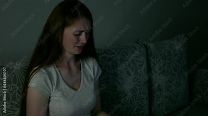 Emotional woman watches drama movie on tv. Adult woman cries and watches drama cinema or soap opera. Female person spends time in front of tv at night or evening.
