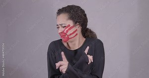 Afro-latin-american woman, afro-haired, serious, with red handprint on her face, saying no, being assaulted, afraid, begging not to be beaten, symbol of impotence, video prevention of violence against