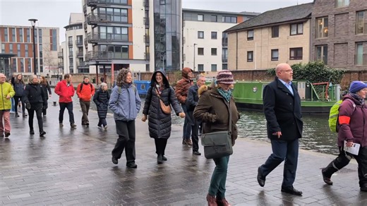 Attendees of the SCVO Gathering talk as they enjoy a guided Health Walk along the canal in Edinburgh. Houseboats and modern apartments stretch along both sides. | Walking Scotland