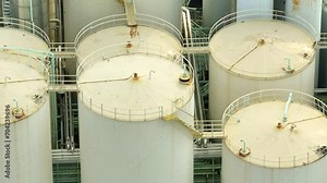A mesmerizing symphony of steel tanks and pipelines weaving through the landscape, the lubricant plant stands as a testament to modern industrial prowess from above. Stock footage.