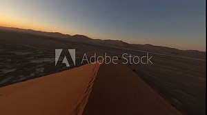 Aerial view with FPV drone flying fast over the edge of a beautiful Dune 45 of Namibia on a beautiful sunset during an adventure trip to the African country