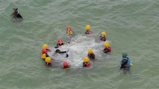 Coasteering group enjoy the elements of wild waves and rugged rocks, All year sport. Cornwall UK