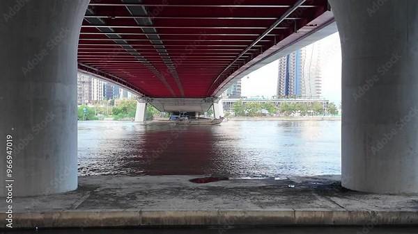 Ba Son cable bridge at Ho Chi Minh city, with big bridge piers, cargo boat cross under modern infrastructure on Sai Gon river