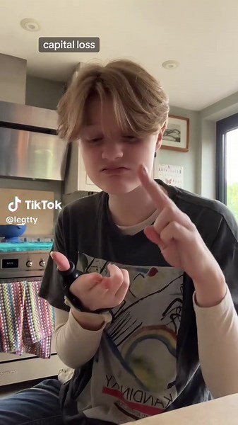 VD: letty is a young white androgynous person with short blonde hair. They are wearing a long sleeve tshirt with a graphic tee over it. They have a thumb brace on one hand. They sign in BSL to the audio. They sign: money decrease, love its law. Belief in religion its taught. End VD. Hashtags: #BSL #Deaf #BritishSignLanguage #GigiPerez #CapitalLoss #LGBT #WLW #NB #NonBinary