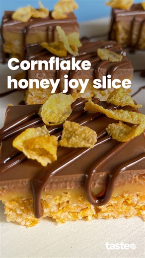 Two Aussie icons, one epic slice. We've fused caramel slice with honey joys to create the ultimate crunchy, chewy caramel treat! After a round of retesting and a few expert tweaks, this honey joy slice is now even easier (and more delicious) to make! If you'd like this recipe, Google 'Taste Cornflake honey joy slice'. #honeyjoy #cornflakes #caramelslice #sweetenedcondensedmilk | Taste.com.au