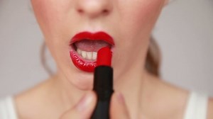 Woman with red lips applying make up