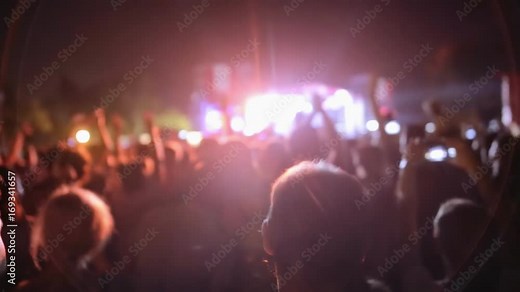 Crowd at concert - Cheering audience in front of bright colorful stage lights