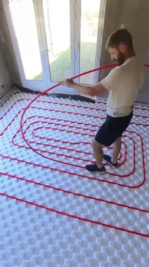 someone is laying a heating pipe or cable on an insulated plate