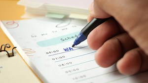 Download writing on a daily planner on table. for free