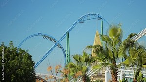 A trailer with people makes a dead loop on a roller coaster ride on a cloudless summer day. High quality 4k footage