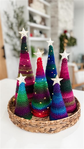Michelle Moore on Instagram: "Comment MABHT4 for links 🎄✨ Your holiday décor just got a little brighter and a lot happier! The Merry and Bright Holiday Trees are the perfect dopamine décor project to add colour, joy, and handmade magic to your festive space. Designed in PRISM from @marymaximofficial this pattern uses three strands held together for a plush, vibrant gradient effect that works up fast and looks stunning. The pattern includes four different tree sizes and a step-by-step YouTube tu