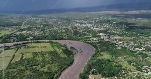 Aeiral drone scene of growing river, flooding rural and urban areas of Mina Clavero, Traslasierra, Cordoba, argentina