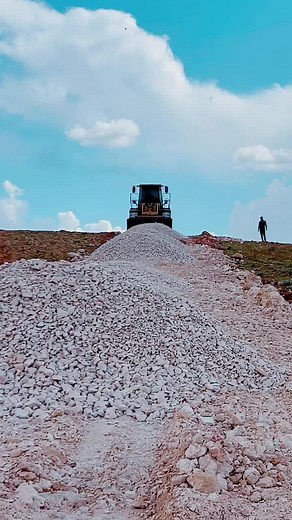 Front Loader Grading Gravel on a Clear Day