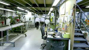 Time lapse of busy workers in the office section of a warehouse or factory