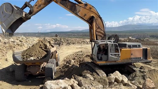 利勃海尔 974 挖掘机和卡特彼勒 352F 液压锤装载 Bell B50D 中的石料层 - Ascon 有限公司