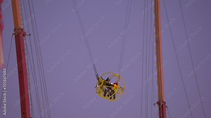 This video shows a sling shot carnival ride with an evening sky in the background. Stock Video