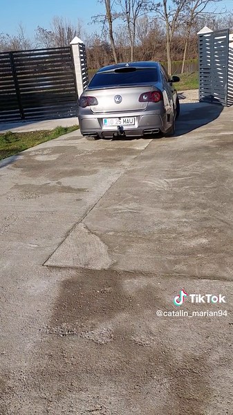 Modern Driveway and Gate Showcasing a Silver Hatchback