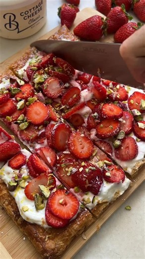 This strawberry & pistachio tart is an easy summertime dessert you can whip up with little effort but amazing results! Think Christmas lunch, Sunday lunch or just because …. Makes 1 30cm tart Ingredients 1 x 30cm square puff pastry 1 egg yolk 250g Brancourts Cottage cheese ¼ cup icing sugar 1 tbsp 1 tbsp 2 tsp rosewater Zest 1 lemon 1 punnet strawberries, trimmed 1/3 cup toasted pistachio, roughly chopped Method Preheat an oven to 220C. Place the puff pastry onto a lined baking tray and mark a 2