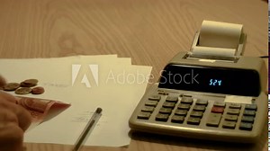 ancient led calculator with ribbon paper and hands counting money, footage to represent business and finance concepts