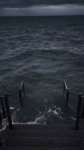 Excavator in Stormy Sea: Rugged Construction Scene