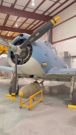 This is our Douglas SBD-4 Dauntless. The Dauntless is a two-seat Scout/Bomber Aircraft with a state-of-the-art low-wing monoplane with multi-cellular wing. This revolutionary development allowed for no external wing braces or stays. Because multi-cellular wings could not fold, the SBD was made very compact. SBDs carried a center-mounted 1,000 lb. bomb on a trapeze that swung the bomb down and forward to clear the prop. The SBD sank more tons of Japanese shipping than all other aircraft combined.