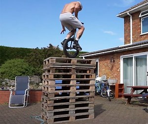 Watch a Unicyclist High Jump onto a Stack of 10 Shipping Pallets
