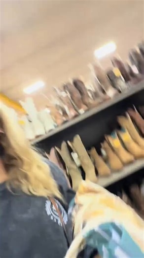 This smoking hot blonde woman walks through the Boot Barn store scanning shelves of cowboy boots then stops at a pair of white embroidered ones with a price tag.She holds up the tag showing one hundred twenty nine dollars and ninety nine cents with wide eyed shock before covering her mouth in disbelief.This spontaneous shopping reaction turns a quick store trip into pure sticker shock comedy.You wonder if spotting dream boots at that price is exciting retail therapy or instant regret in disguise