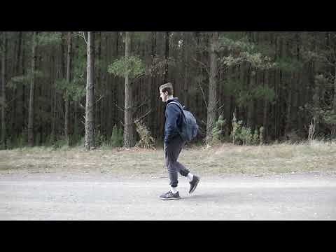 Man walking with hands in pockets - side view