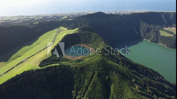 Sete Cidades crater with Lagoa Rasa and Lagoa Verde revealed as the view moves left and opens toward the ocean on Sao Miguel island in the Azores