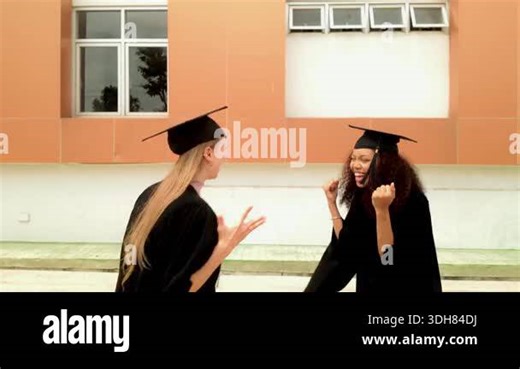 Two graduates in caps and gowns hug and smile outside modern campus building. Joyful moment captures graduation ceremony, college success, university achievement, educational commencement. 4k video Stock Video Footage - Alamy