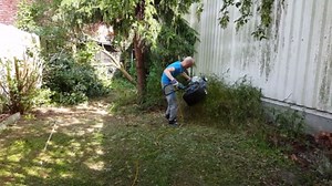 Man Lifts Lawn Mower to Cut Tall Grass