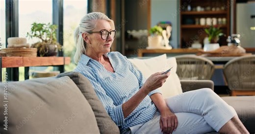 Woman, relax and watching tv with remote on couch, entertainment or subscription for movies in home. Happy, mature person and change channel with controller, chilling and streaming film in lounge