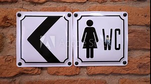 A clear directional sign indicating the womens restroom location with an arrow for easy navigation