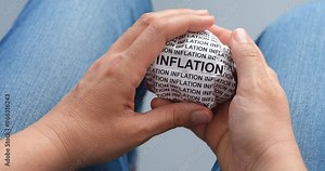A woman is crumpling a paper ball with words Inflation in her hands