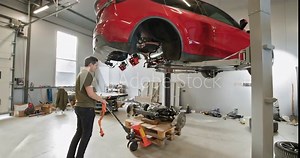 Two mechanics working on a disassembled electric car in a modern garage workshop. EV maintenance and repair concept. EV repair concept. Auto Service, Electric Car Battery Handling.