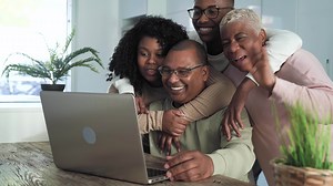 a family is using a laptop together