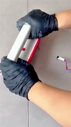 applying specialized tool to smooth the grey wall surface using a manual scraper for better