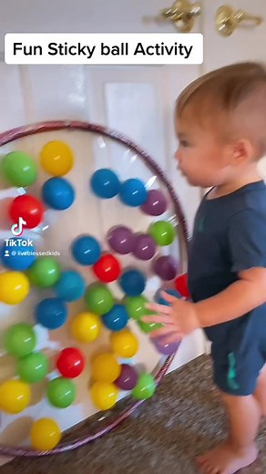 Are you running out of fun things to do with your one year old? Try this activity! It is simple and easy to set up. All you need is a hula hoop, tape, and balls. It will keep your baby busy for 30 mins. This activity will help babies with their motor skills development and cognitive development. #baby #kids #fun #hulahoop #balls #activities #crafts #trend #trending #viral #reels #liveblessedkids