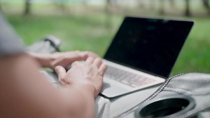 Download Close-up Programmer is writing code, typing on laptop keyboard. Development, graph analysis and typing on a laptop, work stress, working online, anxiety, working in a park, office syndrome. for free