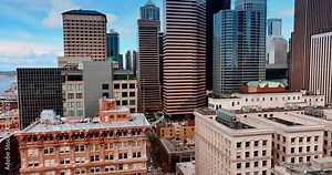 Old-fashioned buildings and modern skyscrapers in the downtown of Seattle, Washington State, the USA. Drone going up along the beautiful architecture.