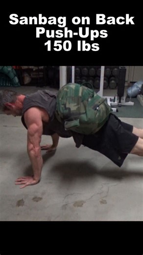 Sandbag on Back Push-Ups 150 lbs - this shows how I get the sandbag onto my back with nobody to set it there. For reference, this sandbag weight almost as much as me (I'm about 175 lbs right now), so there's no real easy way to do it by yourself. This is the best I've come up with and it's actually challenging just on it's own. Basically, I've got the bag standing on end to start with. I sit on the floor beside it, then grab it around the top. Then I powerfully turn over onto my stomach, ideally