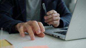 Close-up slow motion of male hand tapping on office desk while businessman in suit is feeling anxiety and stress at work. People and emotions concept.