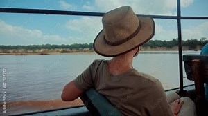 Woman On Africa River Safari Adventure.Safari Trip On Tanzania River.Tourist In Hat On African Safari Adventure On Holiday Vacation.Wild Nature Of Search Crocodile And Hippos Serengeti Or Ngorongoro.
