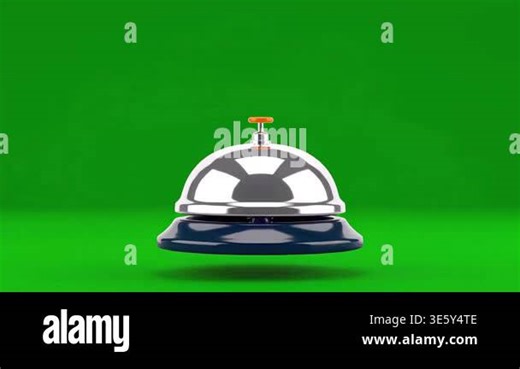 A vintage hotel reception desk bell with a shiny chrome finish sits on a vibrant green surface, isolated against a solid green backdrop Stock Video Footage - Alamy