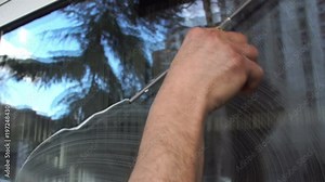 Cleaning the window. A young man cleans and polishes windows with a sponge