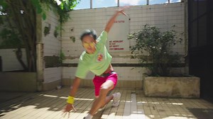 Person crouching on tiled floor in outdoor area