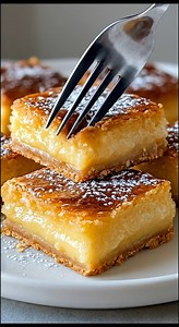 🍰 Gooey Butter Cake Bars | Rich, Golden & Melt-In-Your-Mouth 💛 These gooey butter cake bars take me straight back to bakery cases and family gatherings, where the dessert table always had something rich, sweet, and impossible to ignore. Soft, buttery crust on the bottom… creamy, gooey filling on top… and that lightly crackled golden finish dusted with powdered sugar. They’re the kind of dessert that feels indulgent without being fussy. One bite is all it takes — tender, custardy, and sweet in 