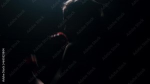 Woman boxer in dark room practicing shadow boxing, female fighter practicing fast punches with back light , 4k