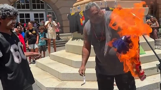 Australian flag set alight at Invasion Day protest in Brisbane