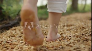 close up feet of a woman walking on a barefoot path in the woods on a summer day 4K ProRes Footage
